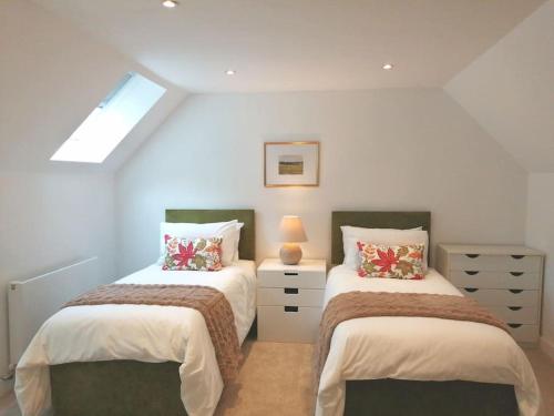 a bedroom with two beds and a skylight at The Highlands - 5 bed 5 bath - Huge Sociable House in Exning
