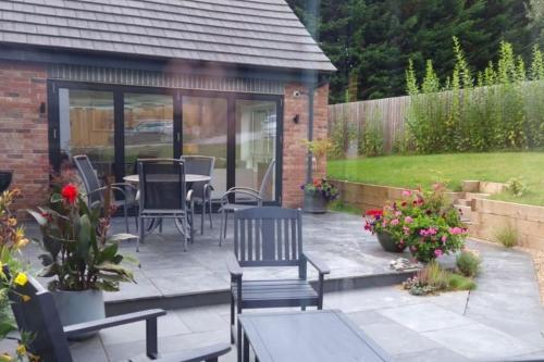 a patio with chairs and a table in a garden at The Highlands - 5 bed 5 bath - Huge Sociable House in Exning