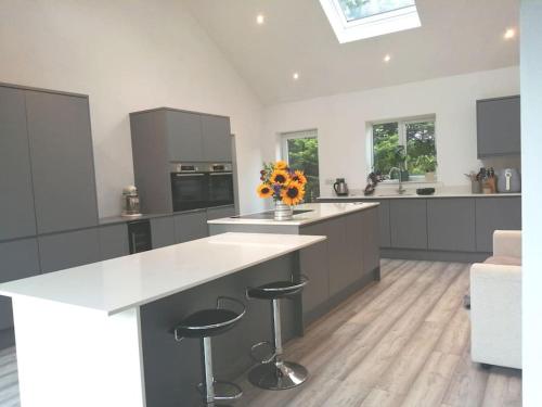 a kitchen with a large island with two stools at The Highlands - 5 bed 5 bath - Huge Sociable House in Exning