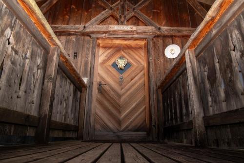 widok na drewniane drzwi w budynku w obiekcie Pineta Natural Chalet w mieście Coredo
