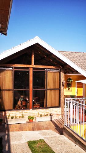 a house with a large window on the front of it at Pousada Geada de Campos in Campos do Jordão