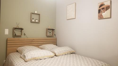a bedroom with a bed with two pillows on it at Gîte du Ka'lao in Saint-Julien