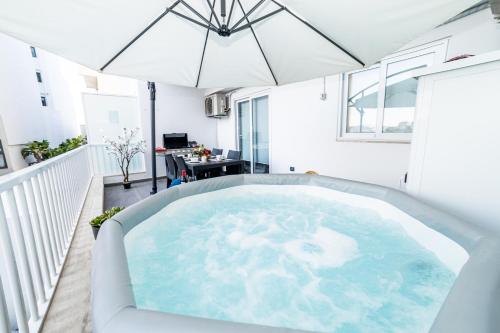 an indoor hot tub in a balcony with an umbrella at Sea Breeze, Spacious 2-Bedroom LUX Seaside Apartments in St. Paul's Bay