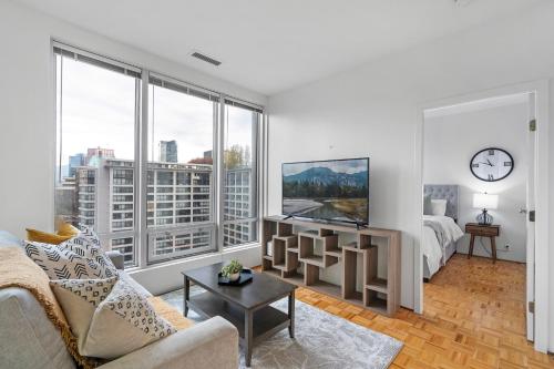 a living room with a bed and a large window at Central Downtown Highrise Condo in Vancouver