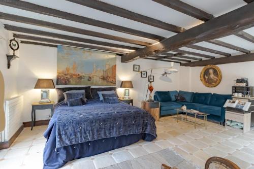 a bedroom with a blue bed and a blue couch at Les Ocelles De Sarlat in Sarlat-la-Canéda