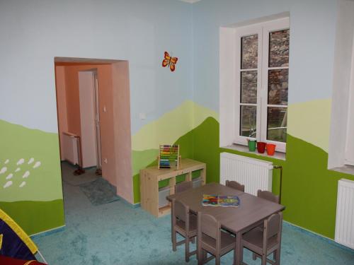 a room with a table and a desk and a butterfly on the wall at Apartmany A.Ša Kašperské Hory in Kašperské Hory