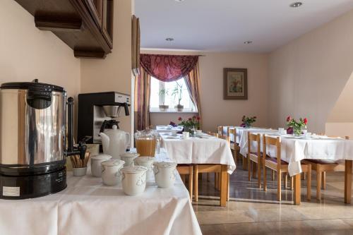 a restaurant with tables with white tablecloths at Pensjonat Adria in Zakopane
