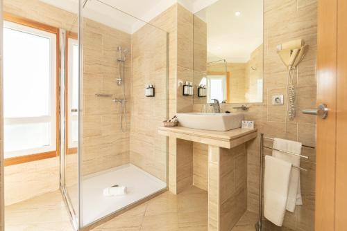 un baño con lavabo y ducha en Hotel Playa Langosteira by Adeloló, en Finisterre