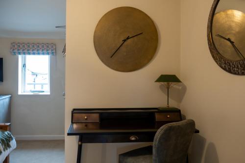 a room with a desk and a clock on the wall at The Red Lion, Madley in Hereford