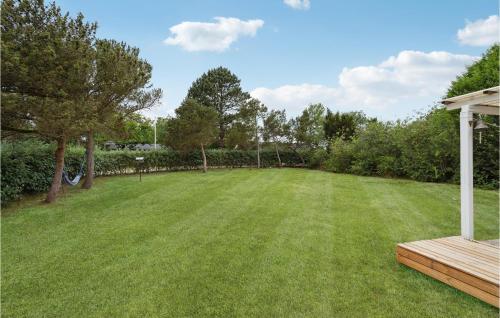 a large lawn with a wooden bench in a yard at 5 Bedroom Nice Home In Asperup in Asperup