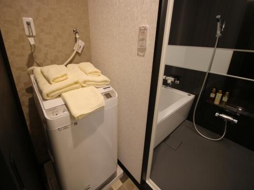 un piccolo bagno con lavatrice e asciugamani di SA Inn Ina Nice Road - Vacation STAY 90164v a Ina