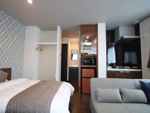 una camera con letto e divano e una cucina di SA Inn Ina Nice Road - Vacation STAY 90164v a Ina