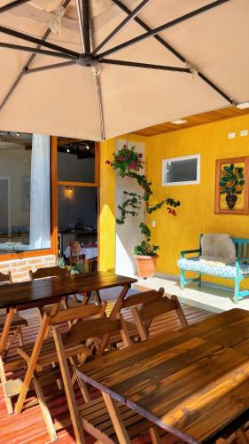 a room with a table and chairs and a yellow wall at Pousada Geada de Campos in Campos do Jordão