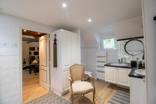 a bathroom with a sink and a chair in a room at Les Ocelles De Sarlat in Sarlat-la-Canéda