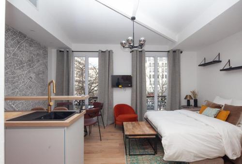 Cet appartement comprend une chambre avec un lit, une cuisine et un évier. dans l'établissement Paris 15 - Tour Montparnasse - Bd Pasteur - 2 pièces, à Paris