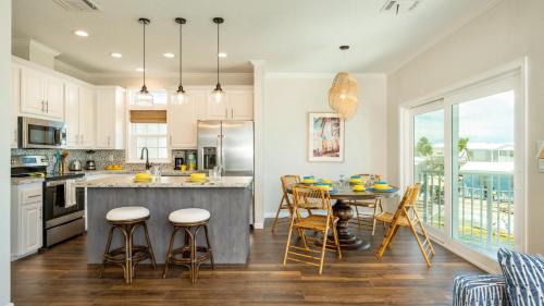 a kitchen with a table and chairs and a kitchen with white cabinets at Mermaid Magic by Last Key Realty in Cudjoe Key