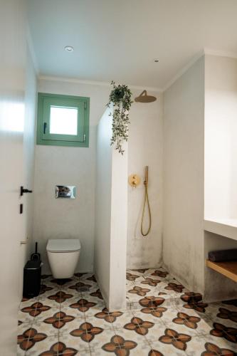 a bathroom with a toilet and a tile floor at Magnolia Villas Potos Thassos in Potos