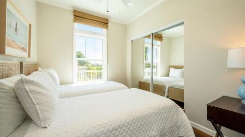 a white bedroom with a bed and a window at Mermaid Magic by Last Key Realty in Cudjoe Key