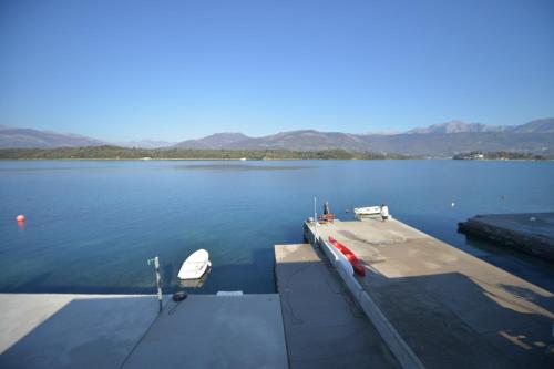 ein Dock mit zwei Booten auf einem großen Wasserkörper in der Unterkunft Apartments and Studios Jokić in Tivat