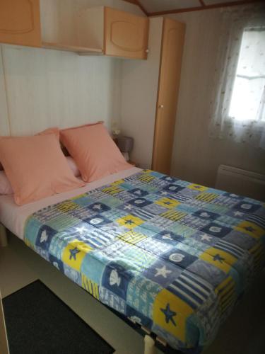 un lit avec une couette dessus dans une chambre dans l'établissement Chalet N 22, à Le Mas