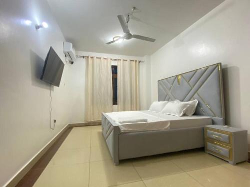 a bedroom with a bed and a flat screen tv at Ocean view homes in Mombasa