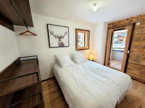 - une chambre dotée d'un lit avec une photo de cerf sur le mur dans l'établissement Appartement Haut de Gamme, 6 Pers, Centre des Gets, Grande Terrasse - FR-1-598-159, aux Gets