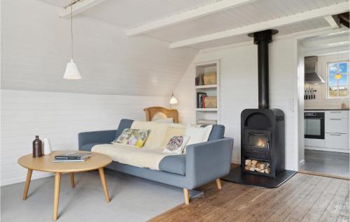 a living room with a blue couch and a stove at 3 Bedroom Amazing Home In Fanø in Fanø