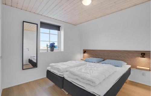 a large bed in a white room with a mirror at 7 Bedroom Gorgeous Home In Ulfborg in Øby