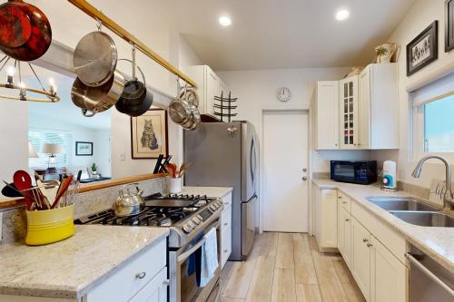 a kitchen with white cabinets and a stainless steel stove at Bangor Lane Oasis in Ventura