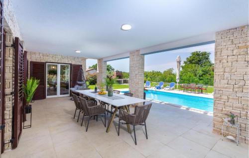 une salle à manger avec une table et des chaises et une piscine dans l'établissement 3 Bedroom Beautiful Home In Sosici, à Sošići