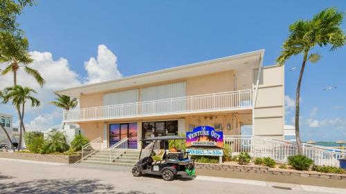a golf cart parked in front of a building at Mermaid Magic by Last Key Realty in Cudjoe Key