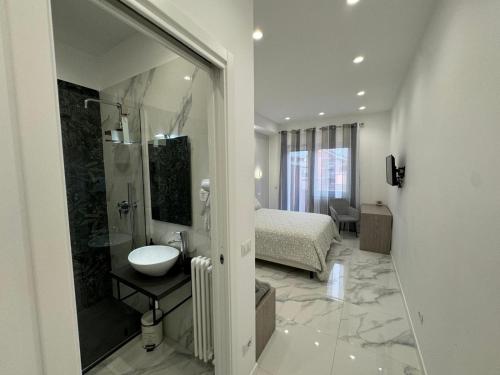 a bathroom with a shower and a sink and a bed at Alba White in Rome