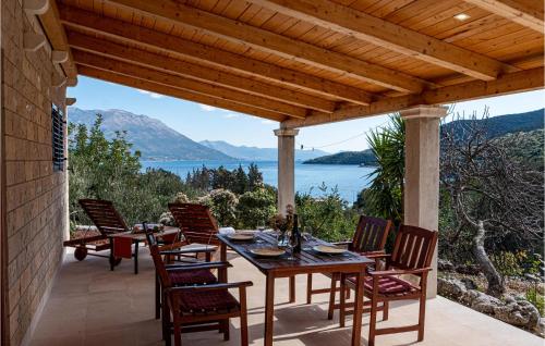 a table and chairs on a patio with a view of the water at Apartment Kneze With Sea View I in Pupnat