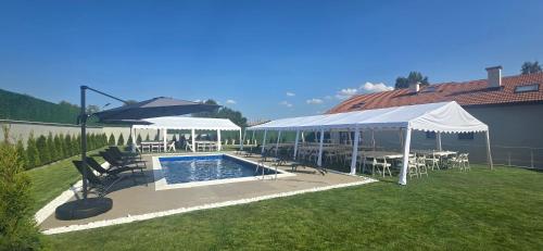 a swimming pool with umbrellas and tables and chairs at Villa Malevitsa Вила Малевица in Relyovo