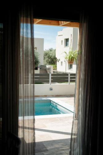 a view of a swimming pool from a window at Magnolia Villas Potos Thassos in Potos