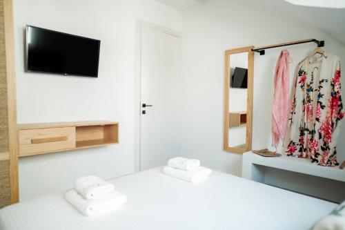 a room with a bed and a mirror and a tv at Magnolia Villas Potos Thassos in Potos