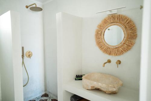 a bathroom with a mirror and a rock on a shelf at Magnolia Villas Potos Thassos in Potos