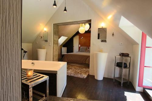 a bathroom with a bed and a tub in a room at Maison ancienne moderne et design - 6 chambres 6 sdb - avec piscine et grand parc in Buxeuil