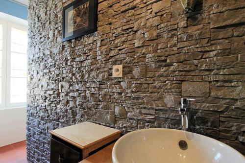a bathroom with a stone wall and a sink at Maison ancienne moderne et design - 6 chambres 6 sdb - avec piscine et grand parc in Buxeuil
