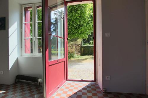 an open red door with a view of a yard at Maison ancienne moderne et design - 6 chambres 6 sdb - avec piscine et grand parc in Buxeuil