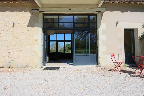 an open door of a building with a red chair at Maison ancienne moderne et design - 6 chambres 6 sdb - avec piscine et grand parc in Buxeuil