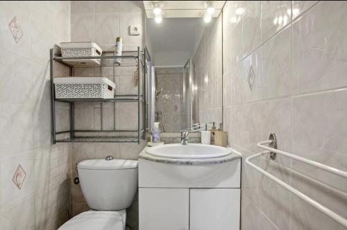 une salle de bain blanche avec des toilettes et un lavabo dans l'établissement Appartement T2 à Fréjus, à Fréjus