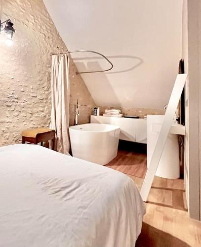 a bedroom with a white bed and a bath tub at Maison ancienne moderne et design - 6 chambres 6 sdb - avec piscine et grand parc in Buxeuil