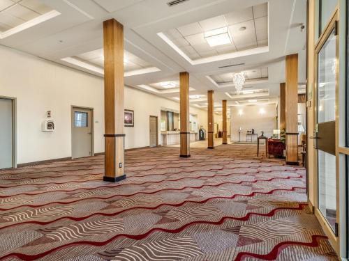 an empty lobby with a large rug on the floor at Holiday Inn Lethbridge by IHG in Lethbridge