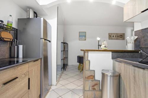 une cuisine avec un réfrigérateur en acier inoxydable et un comptoir dans l'établissement Appartement T2 à Fréjus, à Fréjus