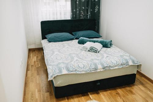 a bed with two pillows on it in a bedroom at Apartman Valerija in Doboj