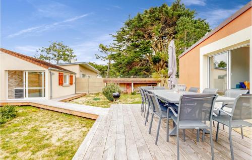un patio con tavolo e sedie su un ponte di Lovely Home In Saint-Germain-Sur-Ay a Bretteville-sur-Ay