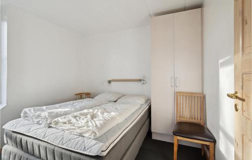 a bed in a small room with a chair at Stunning Home In Kruså With Wifi in Rønsheved