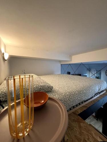 a bedroom with a bed with a table next to it at Studio industriel, mezzanine, rénové, central 201 in Saint-Étienne