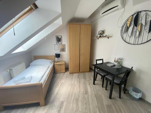a bedroom with a bed and a table with a desk at Pension Lizzi in Vienna